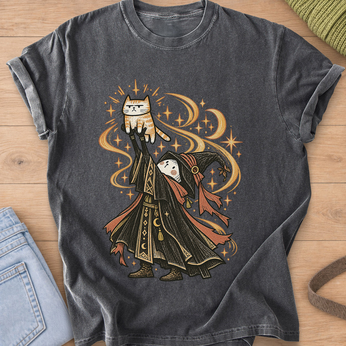 Robed wizard holds a grumpy tabby cat high overhead amid swirling stars and moons on a Pepper T-Shirt