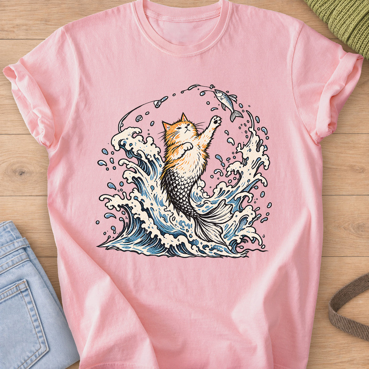 Fluffy cat with a mermaid tail rising from crashing waves, pawing at a hooked fish on a Blossom T-Shirt