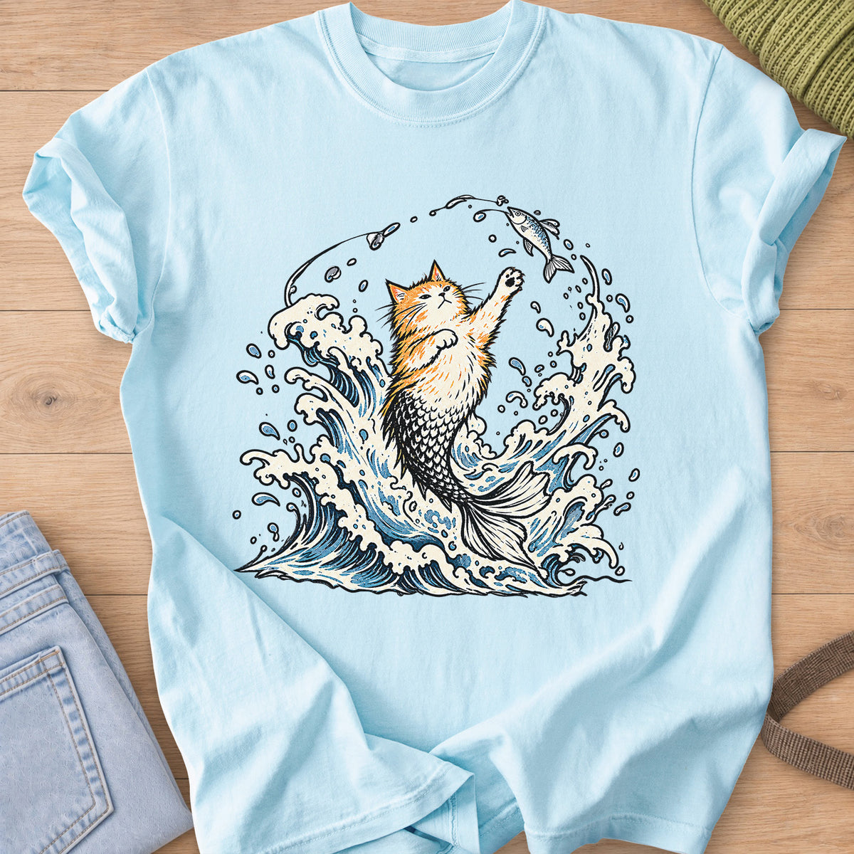Fluffy cat with a mermaid tail rising from crashing waves, pawing at a hooked fish on a Chambray T-Shirt