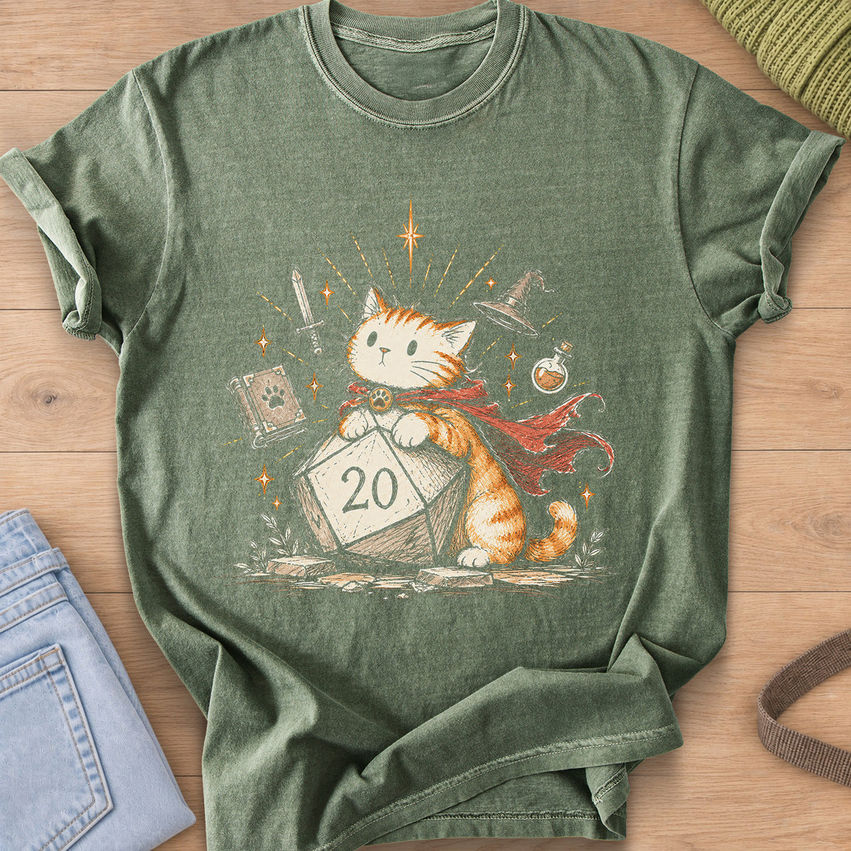 Caped tabby cat leaning on a 20-sided die, sword, spellbook, wizard hat and potion on a Moss T-Shirt