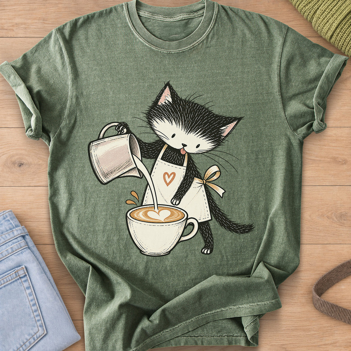 Black and white kitten in an apron pouring milk into a latte with a foam heart on a Moss T-Shirt