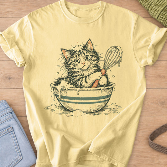 Tabby kitten sitting in a striped mixing bowl of batter, holding a dripping whisk on a Butter T-Shirt