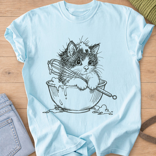 Fluffy kitten in a mixing bowl holding a whisk, with batter dripping over the side, black ink on a Chambray T-Shirt