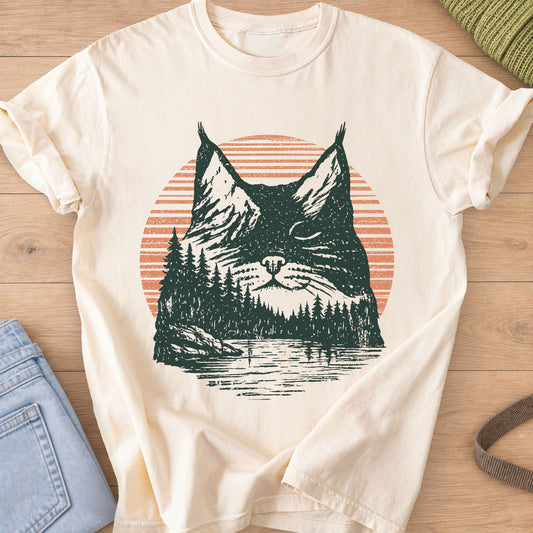 Cat face with closed eyes filled with mountains, pines, a lake and sun, dark green and coral ink on an Ivory T-Shirt