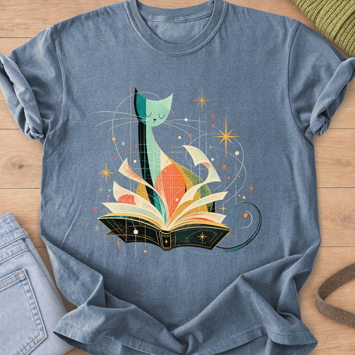 Tall slender cat with closed eyes behind an open book, flying pages and stars on a Blue Jean T-Shirt