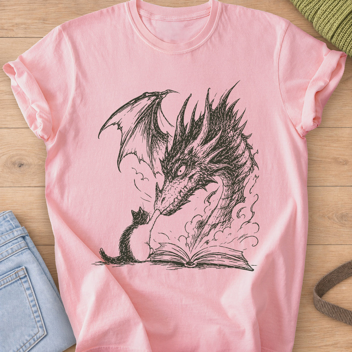 Small cat reaching up to a winged dragon's snout over an open book with smoke, dark charcoal ink on a Blossom T-Shirt