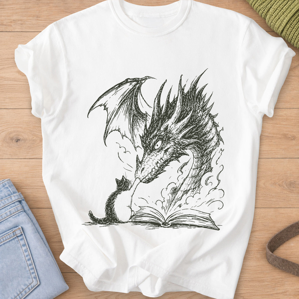 Small cat reaching up to a winged dragon's snout over an open book with smoke, dark charcoal ink on a White T-Shirt