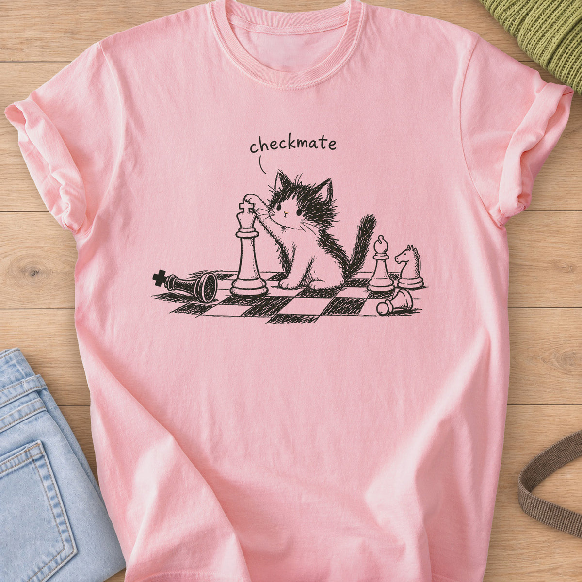 Fluffy kitten with a paw on a chess king, toppled pieces on a board, "checkmate", dark charcoal ink on a Blossom T-Shirt