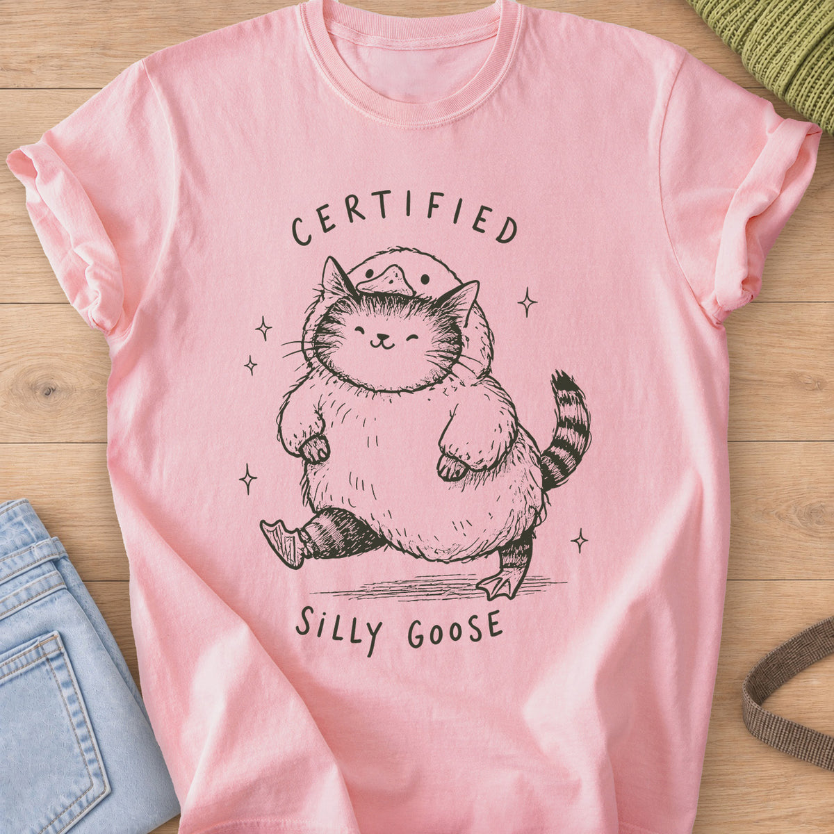Chubby tabby cat in a goose costume walking among sparkles, "Certified Silly Goose", dark charcoal ink on a Blossom T-Shirt
