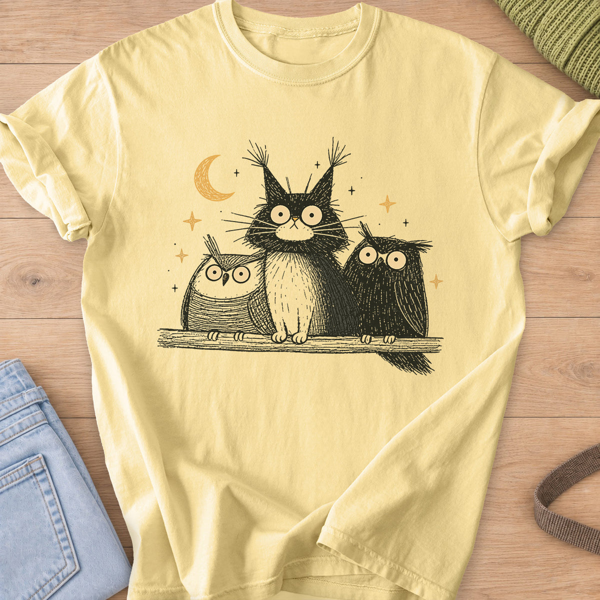 Wide-eyed fluffy cat on a branch between two owls under a crescent moon and stars on a Butter T-Shirt