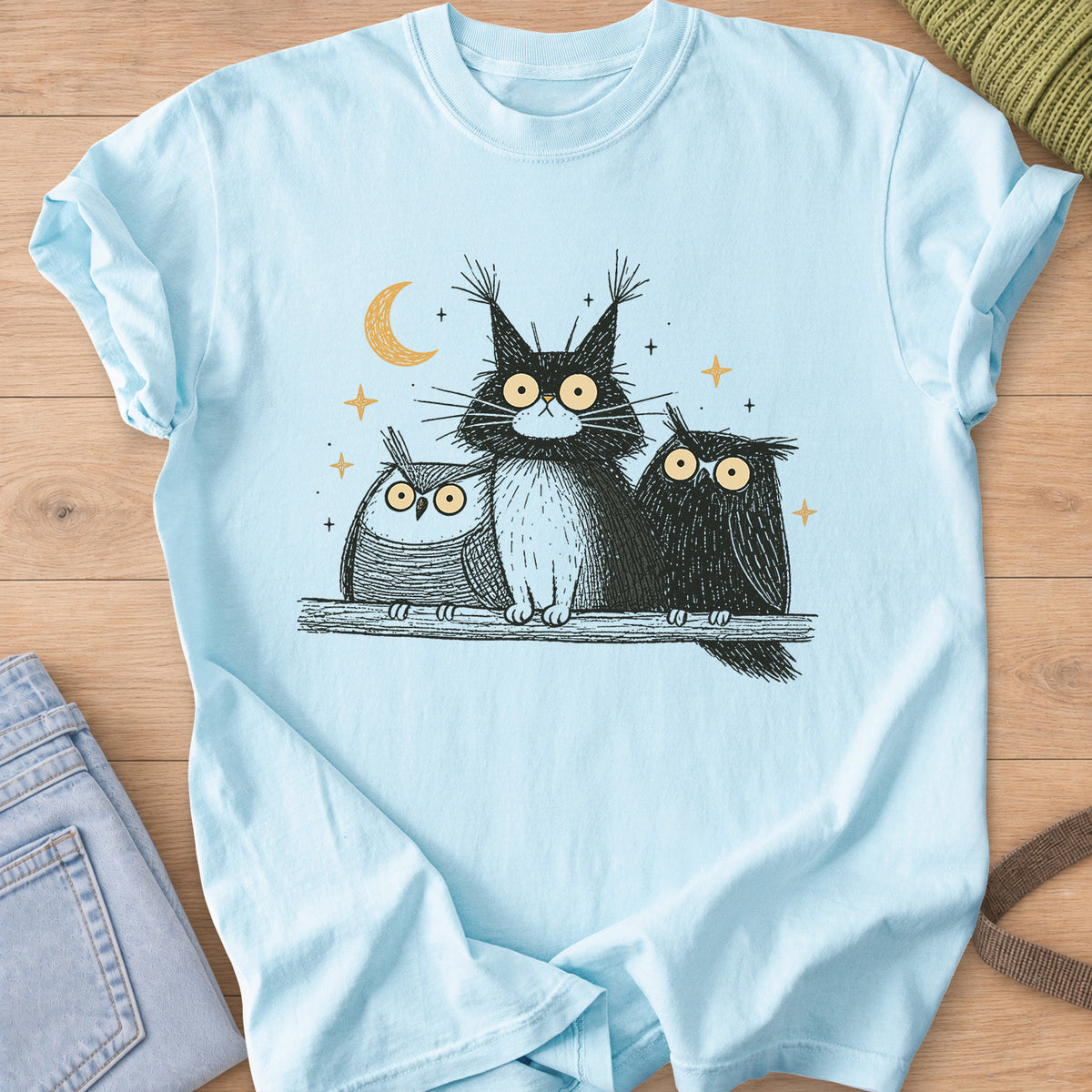 Wide-eyed fluffy cat on a branch between two owls under a crescent moon and stars on a Chambray T-Shirt