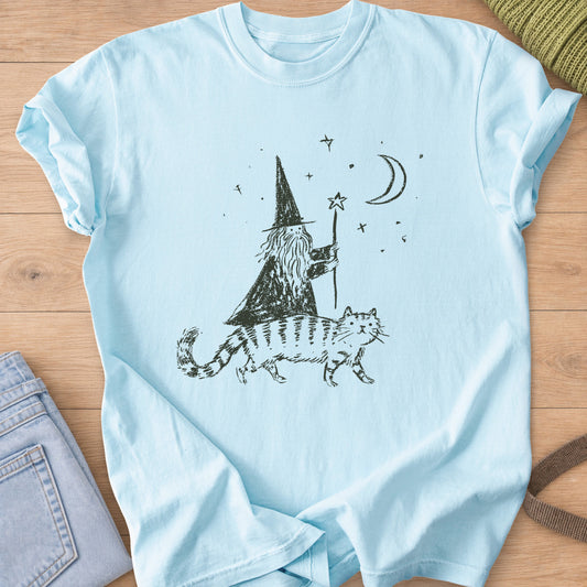 Bearded wizard with a star staff riding a striped cat under a moon and stars, dark charcoal ink on a Chambray T-Shirt