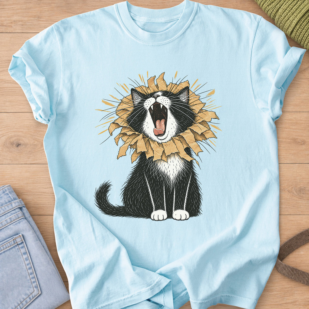 Tuxedo cat roaring with a torn paper bag mane like a lion, sunburst rays behind on a Chambray T-Shirt