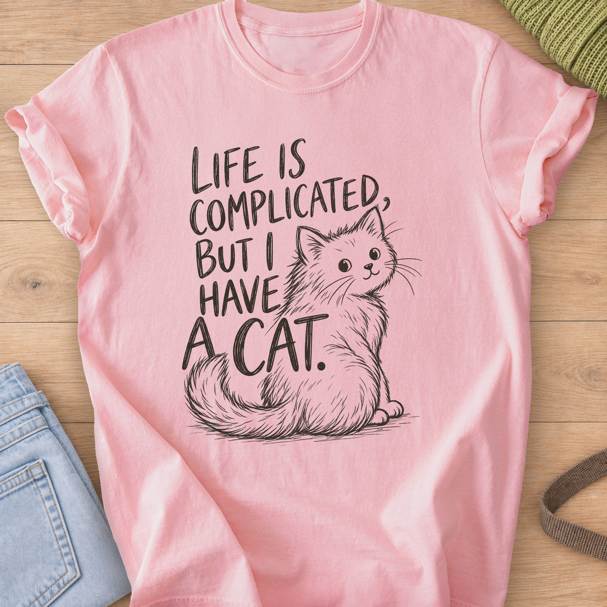 Fluffy cat sits and looks back beside "Life is complicated, but I have a cat.", dark charcoal ink on a Blossom T-Shirt