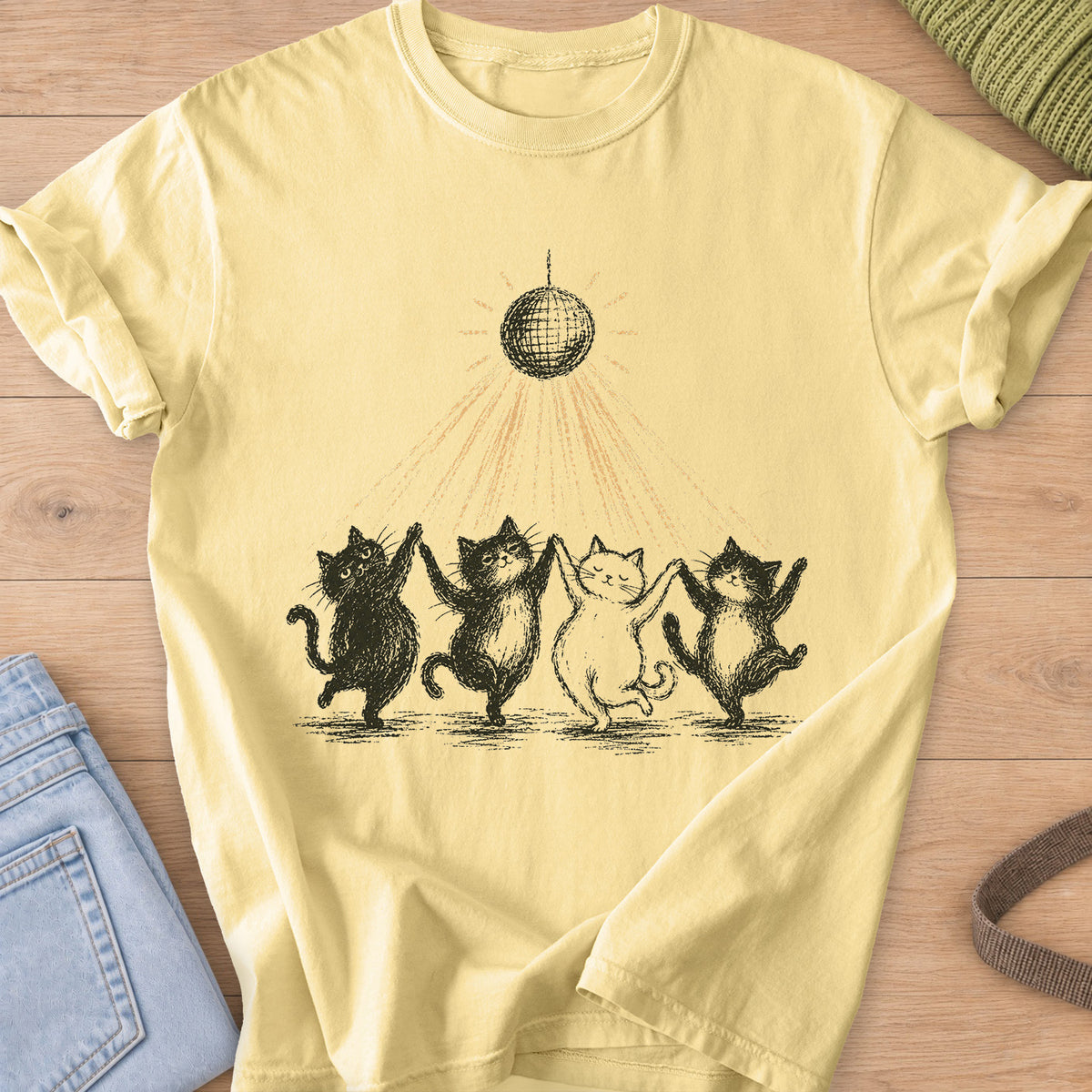 Four cats dancing paw in paw in a line under a disco ball casting light rays, black and gold ink on a Butter T-Shirt
