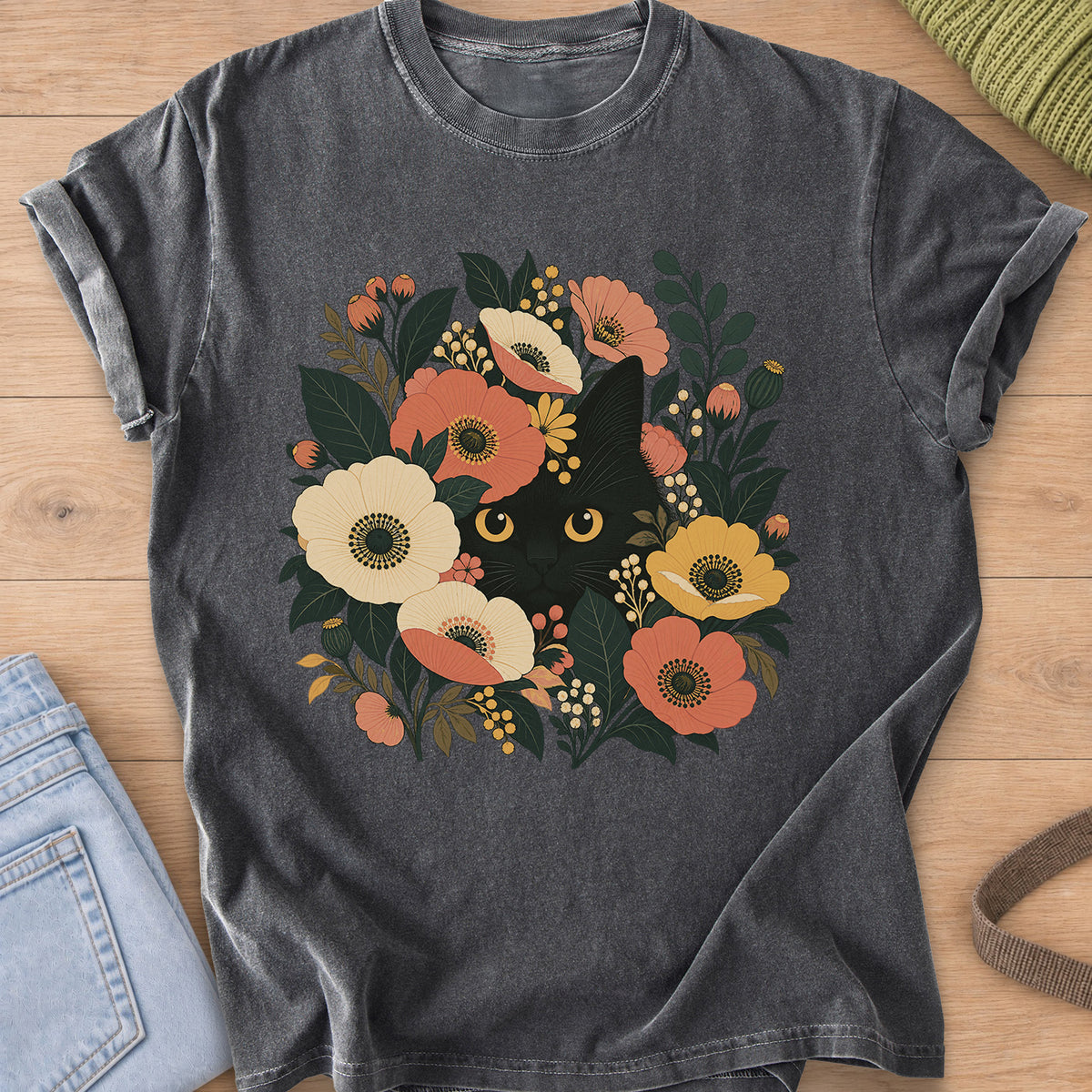 Black cat with round golden eyes peeking out from flowers, leaves and berry clusters on a Pepper T-Shirt