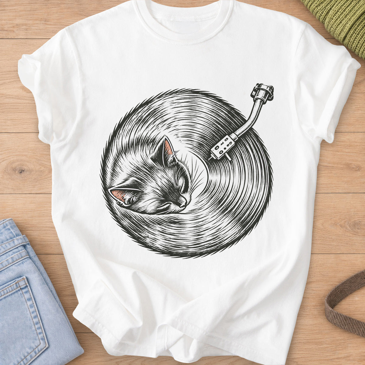 Sleeping cat curled up, its fur forming a vinyl record under a turntable arm, dark charcoal ink on a White T-Shirt
