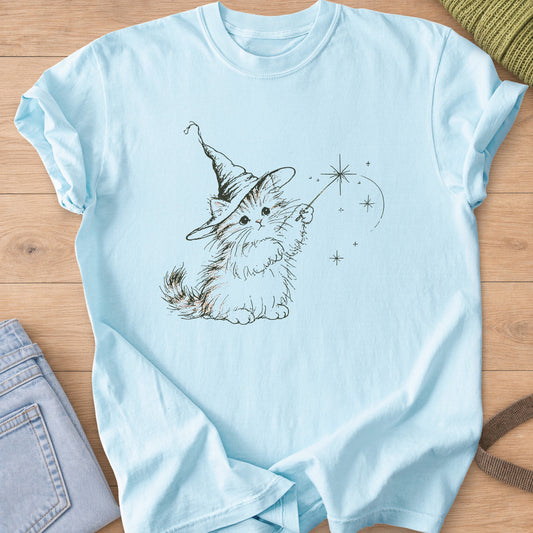 Fluffy kitten in a pointed wizard hat waving a magic wand with star sparkles, dark charcoal ink on a Chambray T-Shirt