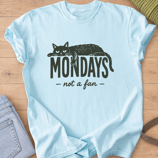 Grumpy cat lying draped over the word "Mondays" with "not a fan" in script below, dark charcoal ink on a Chambray T-Shirt