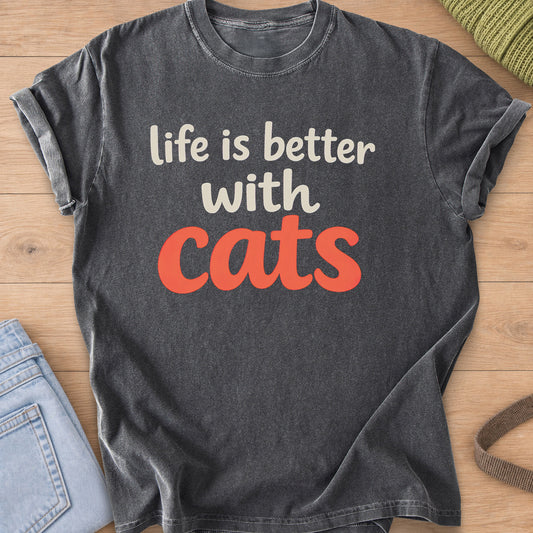 Rounded script reading "life is better with cats" with "cats" in large letters, cream and coral ink on a Pepper T-Shirt