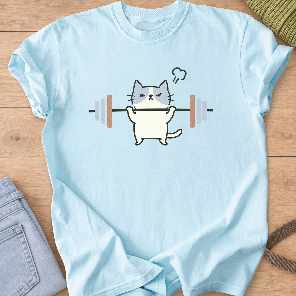 Patched cat squinting as it lifts a barbell, a puff of steam over its head on a Chambray T-Shirt