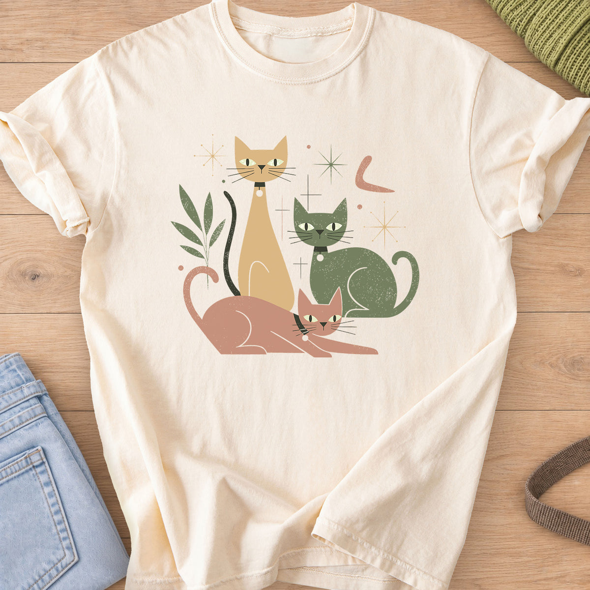 Three mid-century cats with collars posing among starbursts and a leafy sprig on an Ivory T-Shirt
